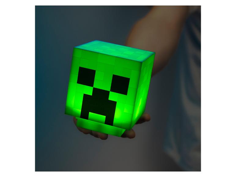 Lichtgevende groene doos met monstergezicht, in de hand gehouden