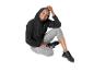 Vrouw in zwarte hoodie en grijze legging, zittend en glimlachend.