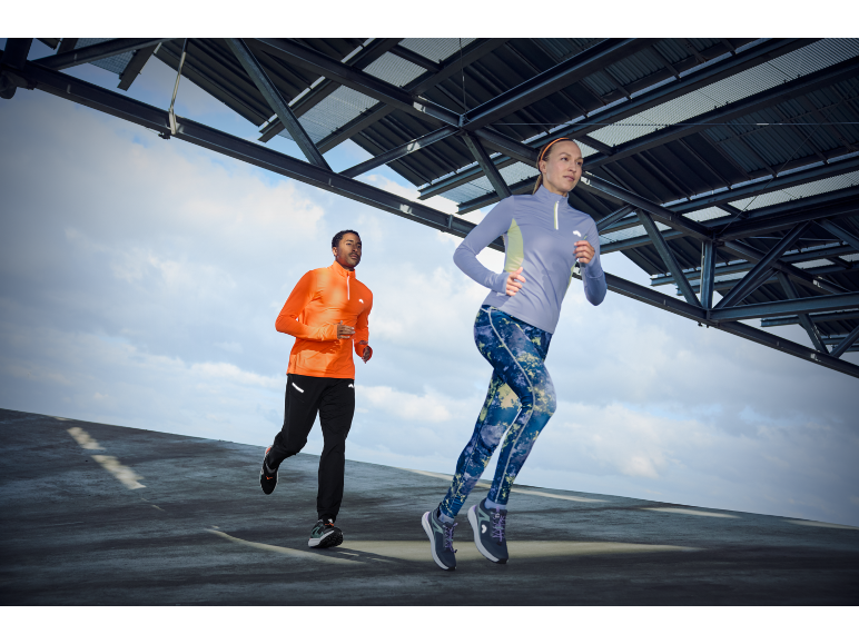 Twee hardlopers in sportkleding, man in oranje shirt, vrouw in paars shirt en legging.