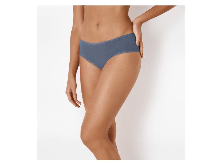 Onderlichaam van een vrouw in blauwe slip, met één hand op haar heup.