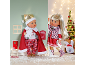 Twee kerstpoppen in feestelijke kleding in een speelse winterse omgeving.