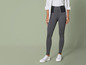 Een model draagt ​​zwarte leggings met een witte blouse en witte sneakers.