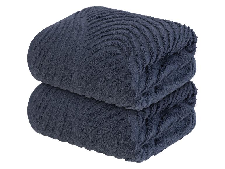 Twee donkerblauwe badhanddoeken met een golvend patroon.