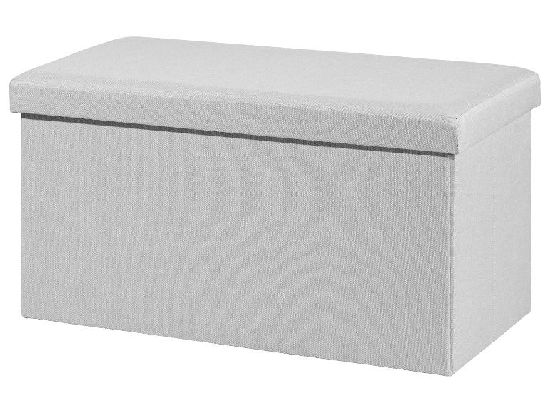 Een lichtgrijze opbergpoef van stof met een gestoffeerde bovenkant.