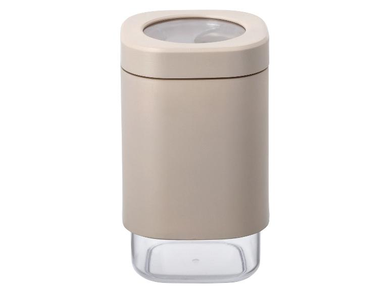 Een beige kruidenpot met een transparant deksel.