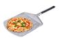 Versgebakken pizza met basilicum op een metalen pizzaschep.