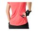 Vrouw in roze fitness-T-shirt en handschoenen, stopt een energiereep in een zak.