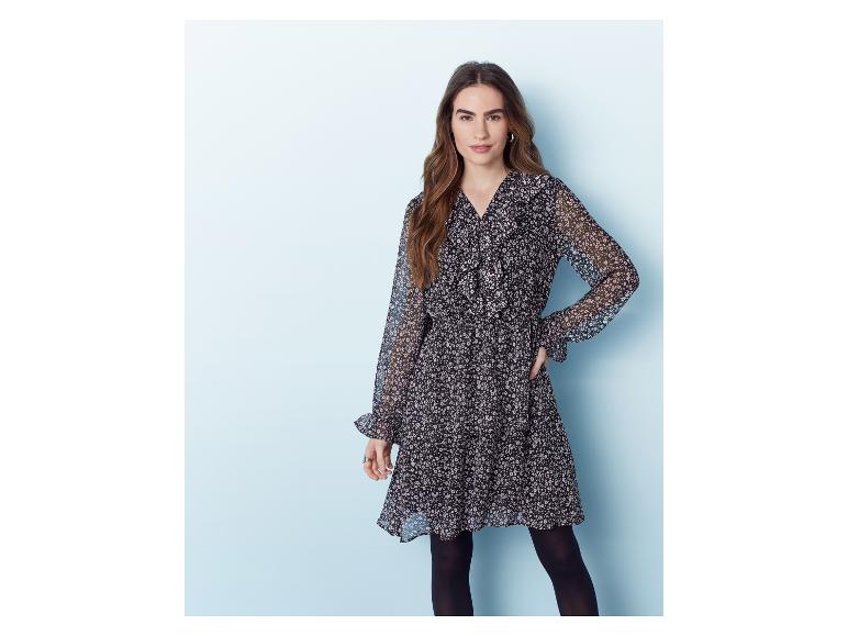 Een vrouw draagt een zwarte jurk met bloemenprint