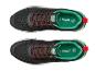 Paar zwarte en groene sneakers met rode veters, met '30 YEARS EST. 1996' op de tong.