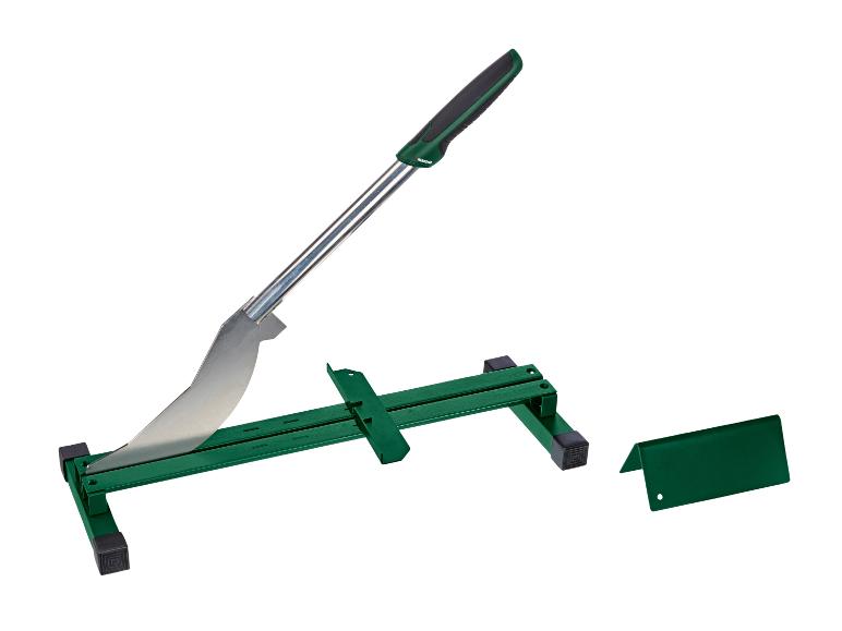 Een groene bestratingssnijder met een metalen mes en een basis, naast een extra onderdeel.