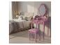 Roze kaptafel met spiegel en kruk in een slaapkamer.