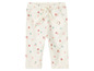 Witte babybroek met roze en groene stippen.