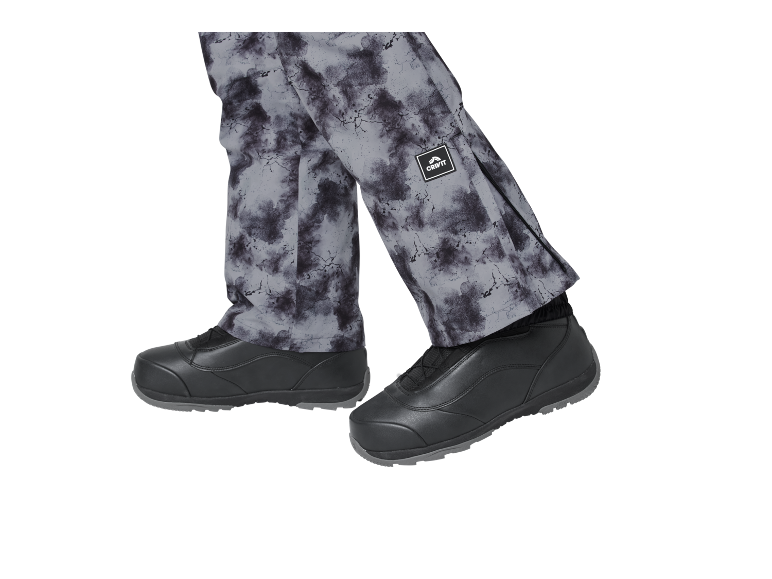 Grijze bedrukte broek en zwarte schoenen.
