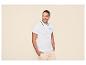 Man in een wit poloshirt met zwarte bies en lichtbeige cargoshorts.