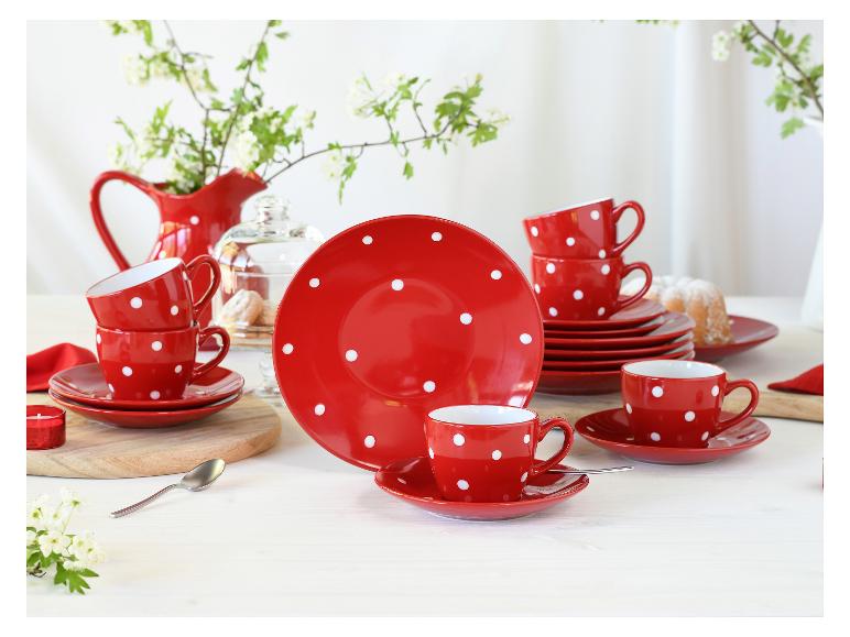 Rood servies met stippen, inclusief kopjes, borden en een kan op een witte tafel.