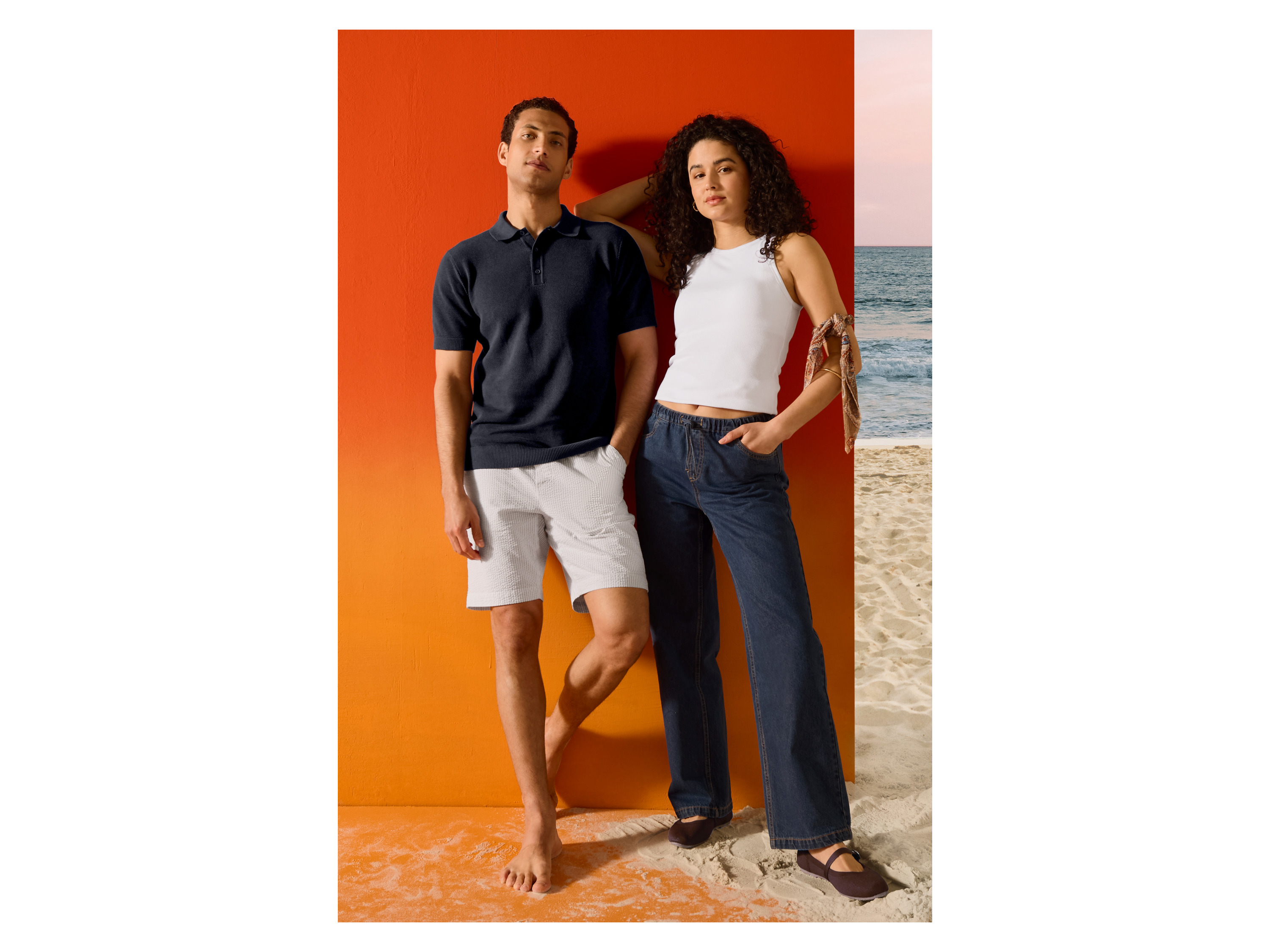Man in donkerblauwe fijngebreide poloshirt van ESMARA MEN en vrouw op het strand.