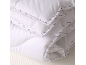 Wit gevouwen dekbed met een subtiel patroon van het woord 'Emma' in blauw.