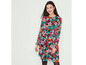 Vrouw draagt een lange, zwarte jurk met bloemenprint.