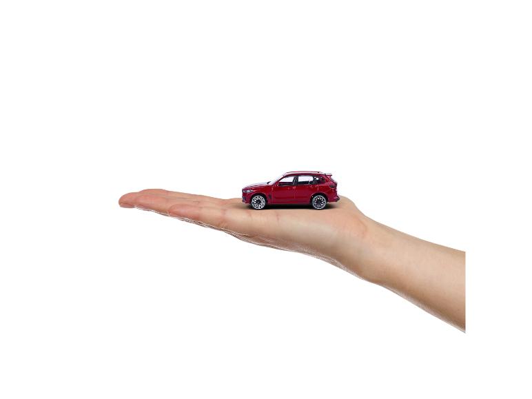 Rode speelgoedauto op een open handpalm.