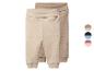 Twee beige en lichtbruine babybroeken met boorden en een omvouwbare tailleband.