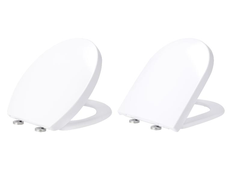 Twee witte, ovale toiletbrillen op een witte achtergrond