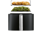 Airfryer met kip en sperziebonen op roosters.