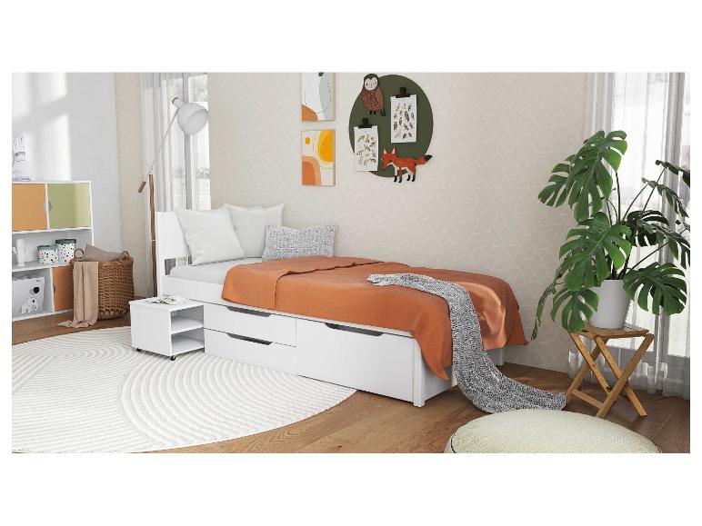 Wit kinderbed met laden en nachtkastje.