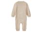 Beige babyromper met lange mouwen en gesloten voetjes.