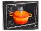 Oranje geëmailleerde gietijzeren braadpan in een oven