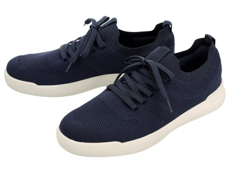 Een paar marineblauwe gebreide sportschoenen met witte zolen.