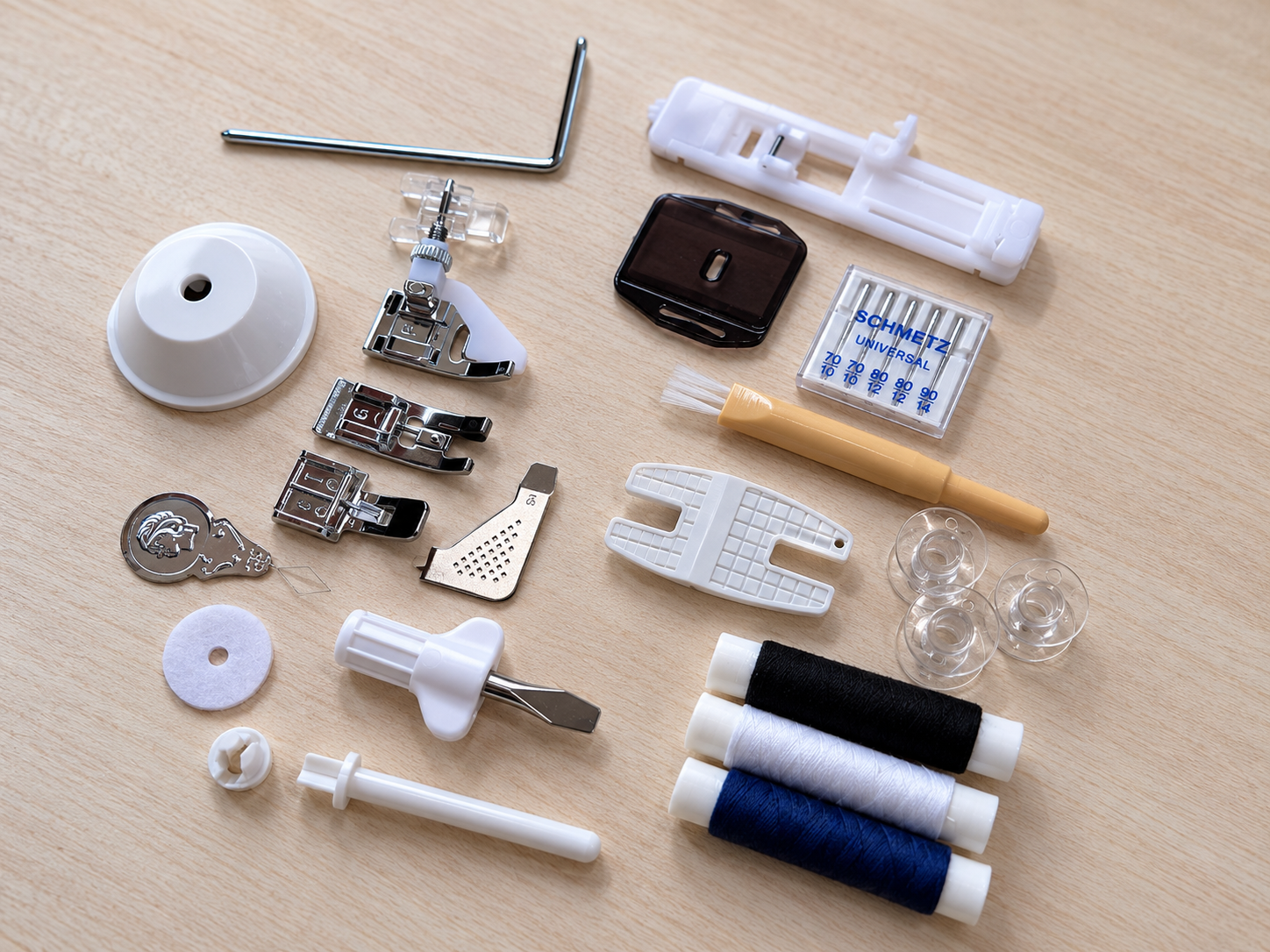 Overzicht van de inbegrepen accessoires zoals naaimachinevoetjes, spoelen, garen en gereedschap, uitgespreid op een tafel