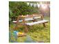 Houten kinderpicknicktafel met twee zand-/waterbakken en kussens met sterrenpatroon.