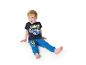 Lachende jongen in blauw T-shirt en joggingbroek met raceauto-opdruk.