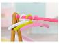 Kleurrijke BABY born hangers aan een roze kledingrek.