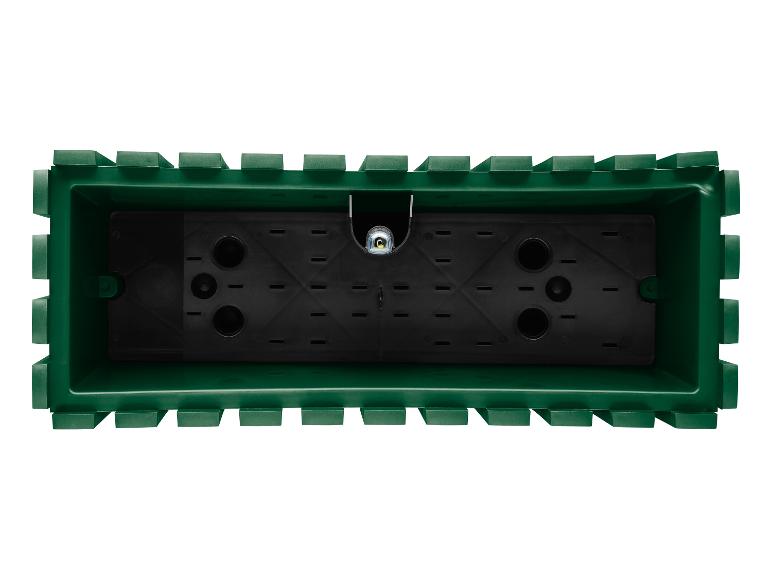 Een groene plantenbak met drainagegaten.