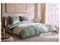 Slaapkamer met bed met bloemig beddengoed en plaid, naast een raam.