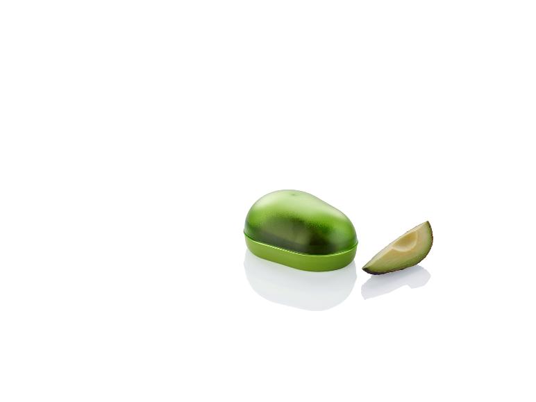 Een groene plastic avocado-opbergdoos en een schijfje avocado.