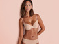 Een vrouw in een beige bh en slipje.