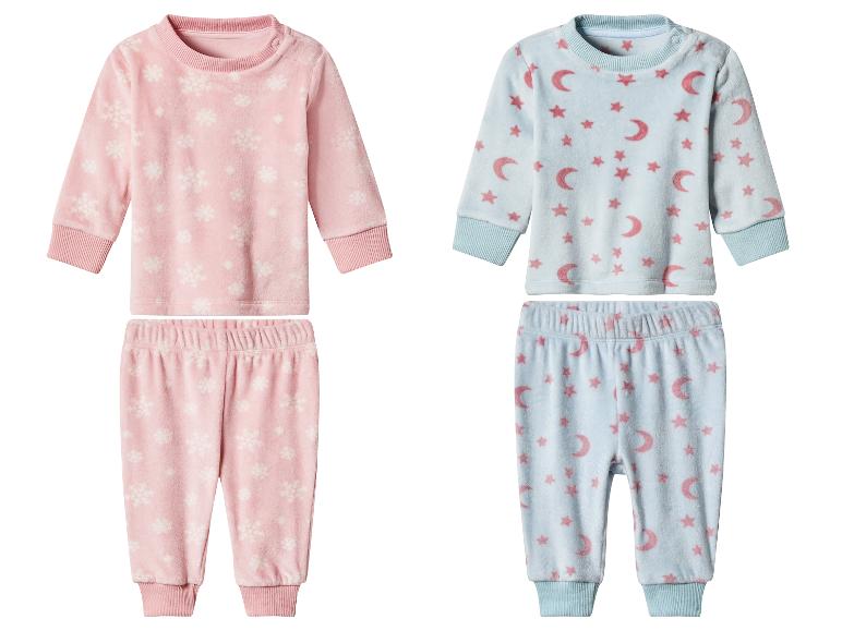 Twee sets babypyjama's: roze met sneeuwvlokken en blauw met manen en sterren.