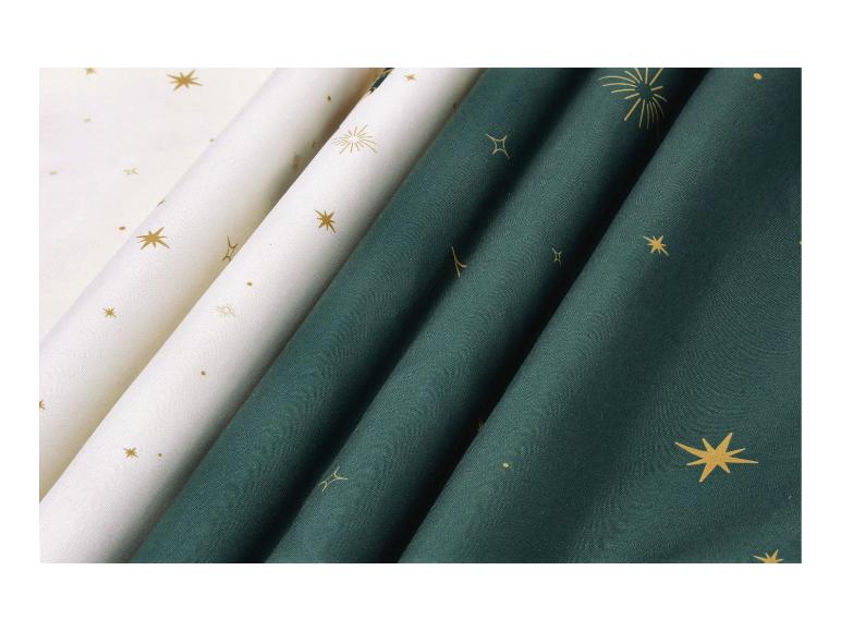 Witte en donkergroene stoffen met gouden sterren- en vuurwerkprints.