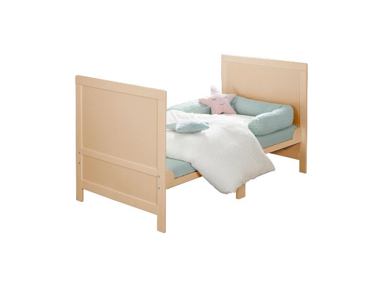 Licht houten ledikant met blauw en wit beddengoed, stervormig kussen.