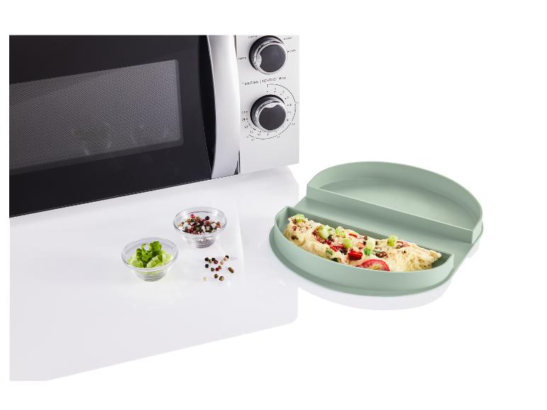 Een magnetron met een omelet in een groene siliconen serveerschaal.