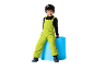 Lachend kind in felgroene skioverall en zwarte muts, zittend op een blauwe cilinder.