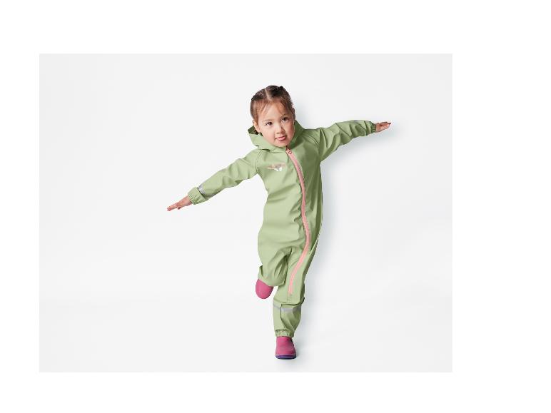 Een meisje draagt een groene regenpak met vlinders en roze laarzen.