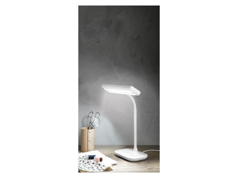 Moderne witte bureaulamp op een houten tafel.