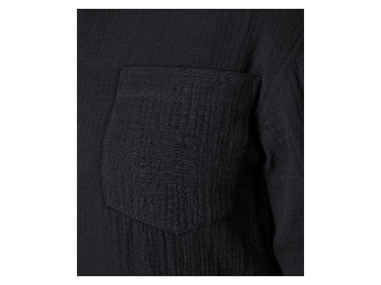 Detail van een zak op een zwart mousseline overhemd.