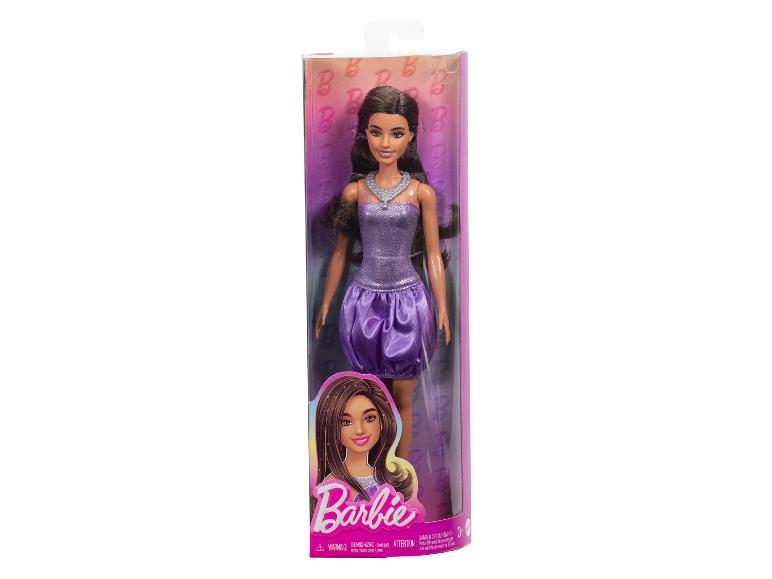 Een Barbiepop in een paarse jurk en zilveren ketting, in de verpakking.