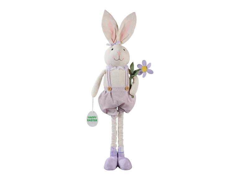 Paashaas knuffel in paarse tuinbroek, met een bloem en een 'Happy Easter' label.