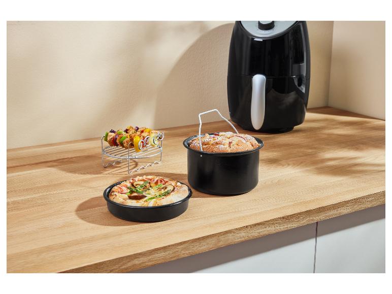 Geroosterde gerechten en desserts in zwarte vormen in een airfryer.