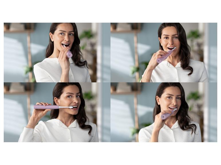 Een vrouw lacht terwijl ze haar tanden poetst met een paarse elektrische tandenborstel.